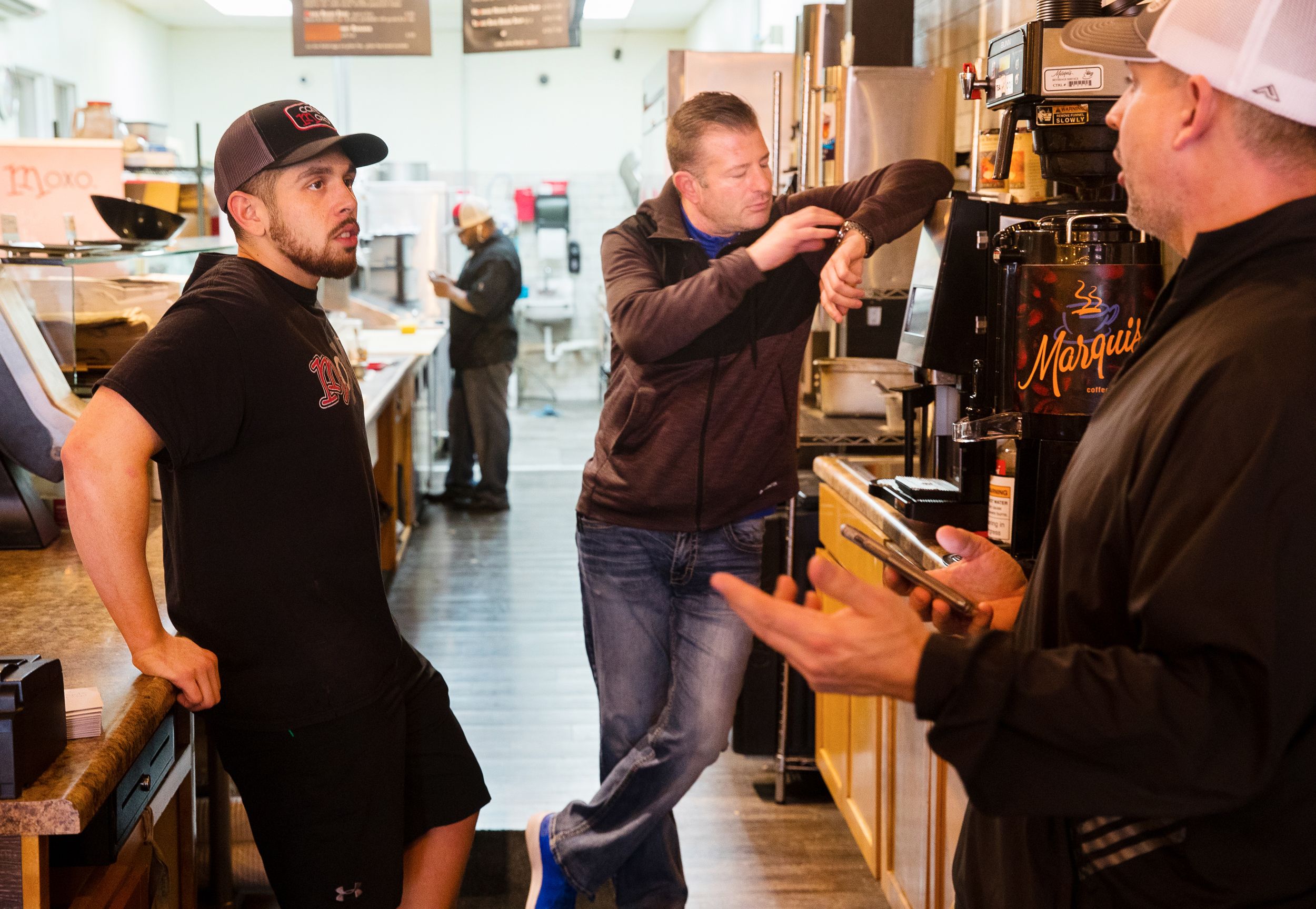 Three restaurant workers wait in the kitchen for customers during a normally busy lunch hour shift.