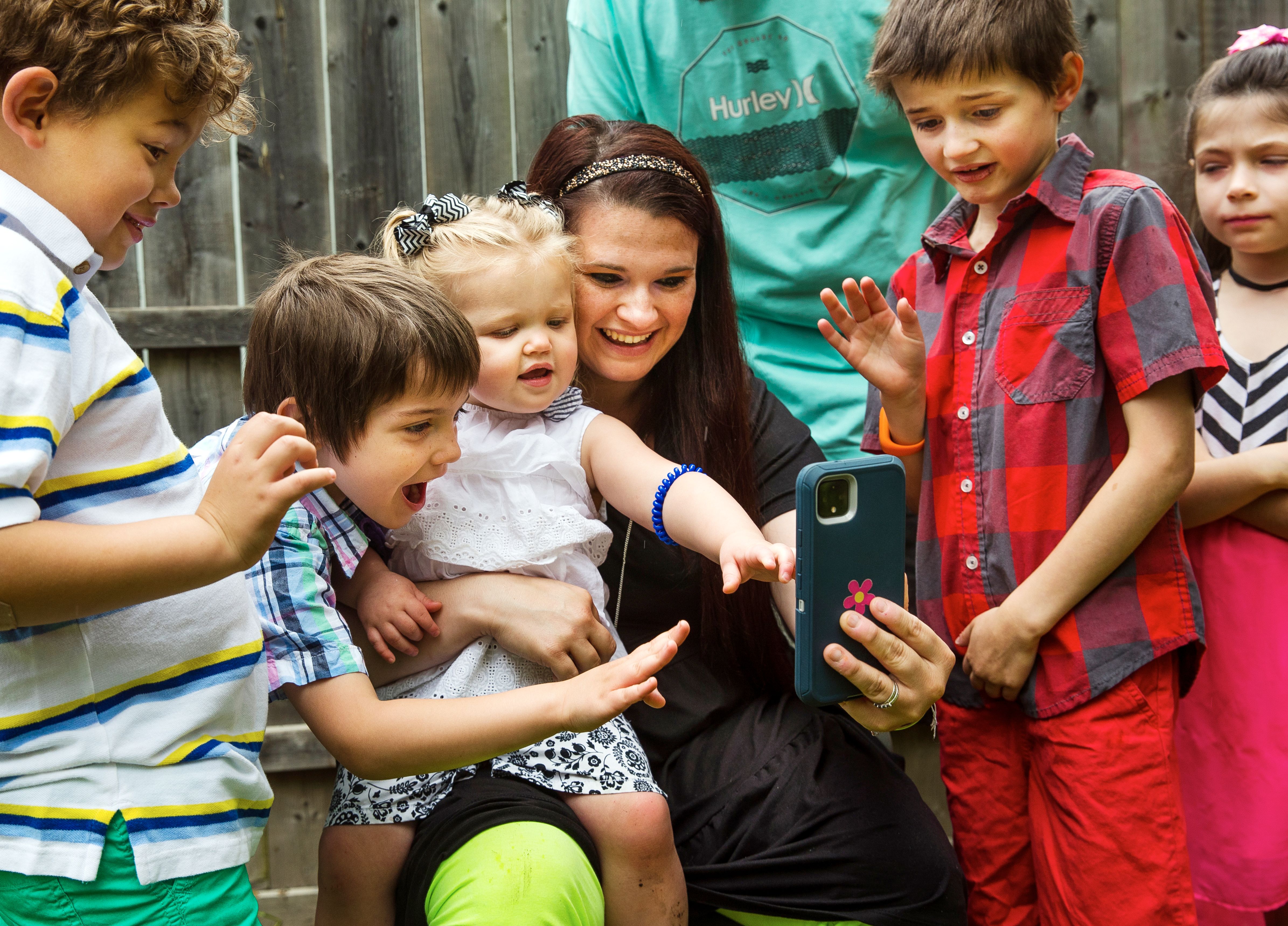 Woman surrounded by her five children while on video call with her mother who is hospitalized amid a no-visitors period due to Covid 19.