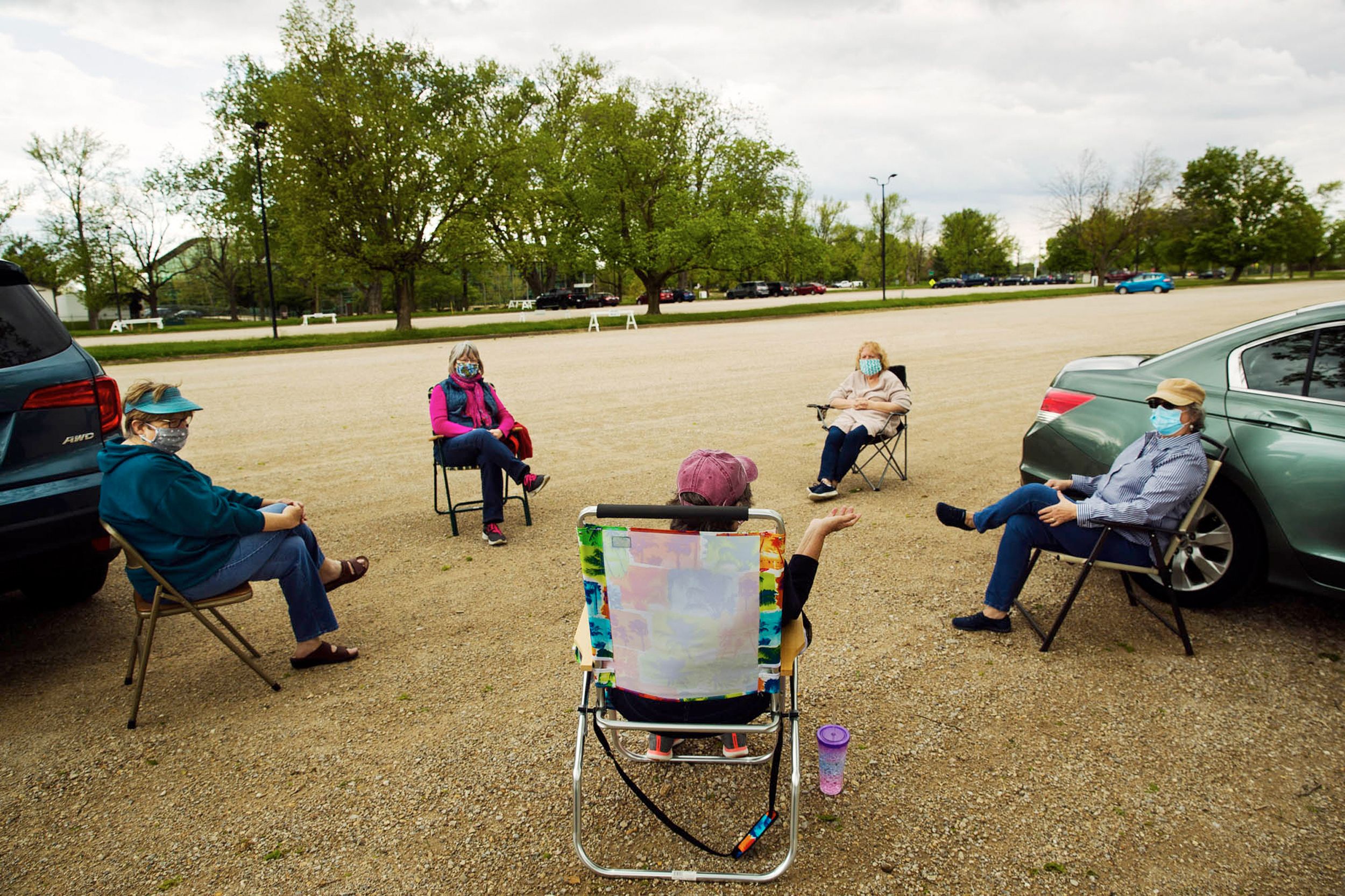 Five masked women socially distance in a parking lot at Illinois State Fairgrounds, May 2020.