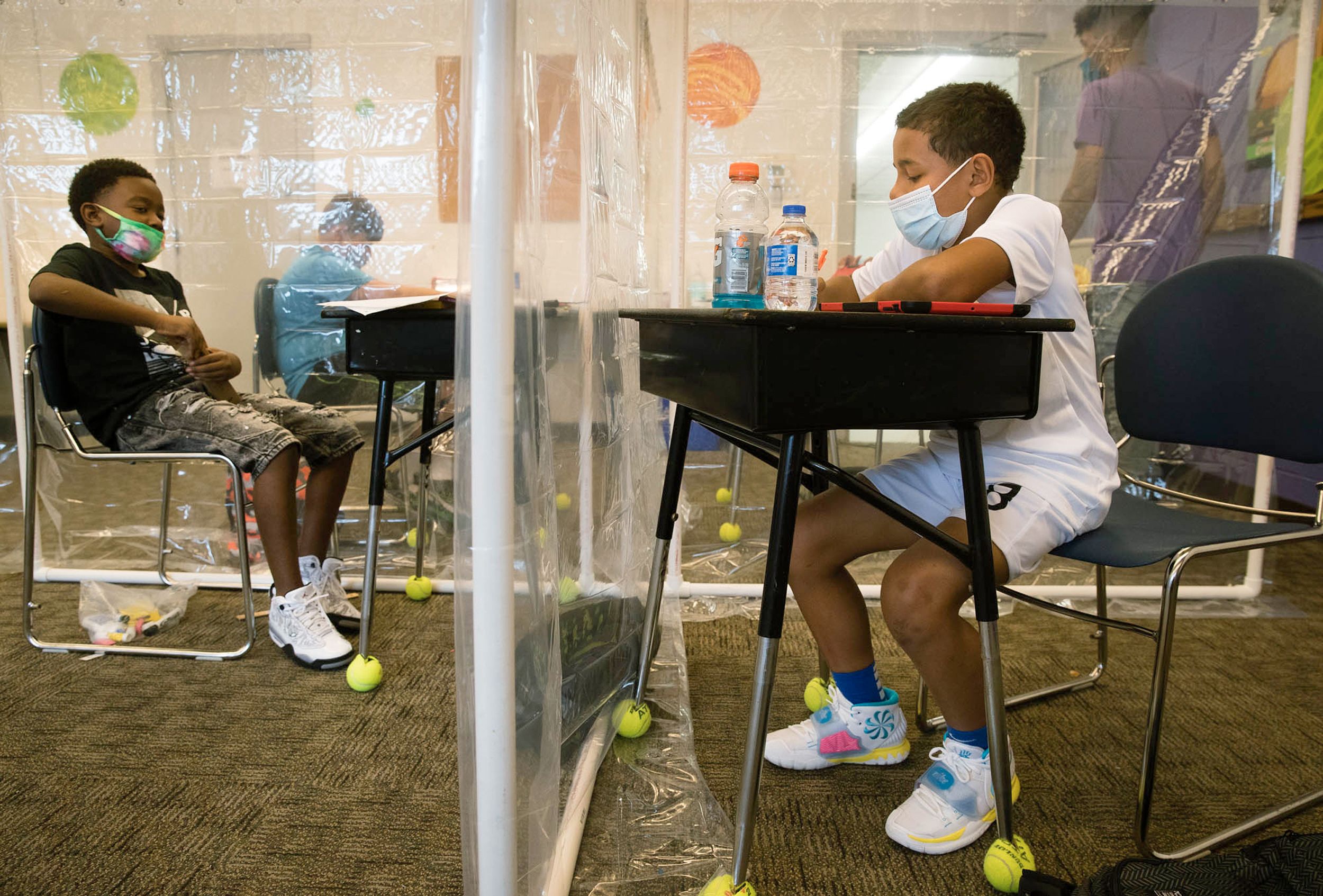 Fifth grade students separated by plastic barriers work at desks during first day of school, Springfield, August 2020.